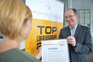 Dr. Uwe Poehls mit Top-Lokalversorger-Urkunde