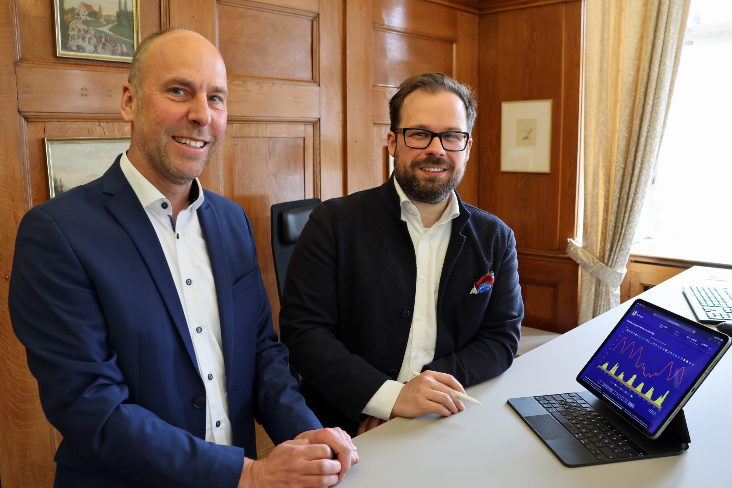 Oberbürgermeister Jan Rothenbacher und LEW-Kommunalbetreuer Andreas Bayer (l.) verfolgen aufmerksam die Daten des Energiemonitors für Memmingen. Alexandra Wehr / Stadt Memmingen