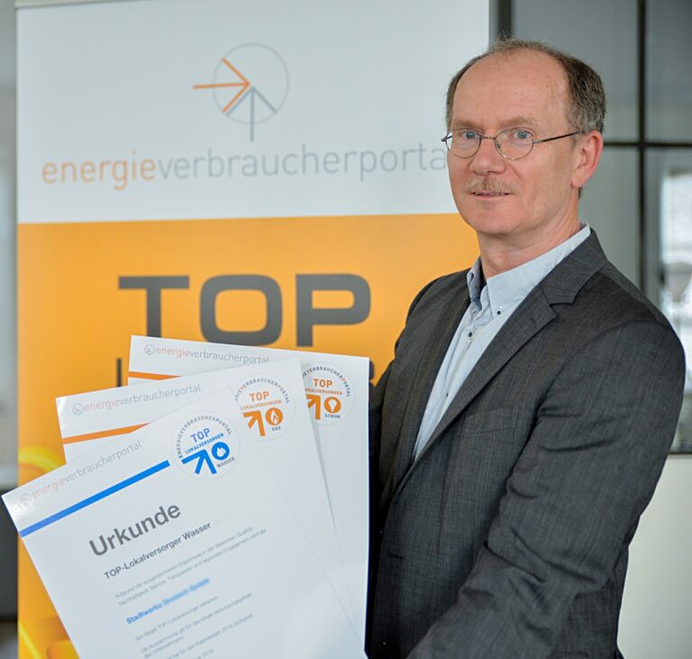 Dr Uwe Poehls präsentiert Siegel Top Lokalversorger